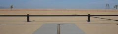 AVBD 951 post and beam vehicle barrier installed across a crash test approach, two steel posts and a continuous blocking beam